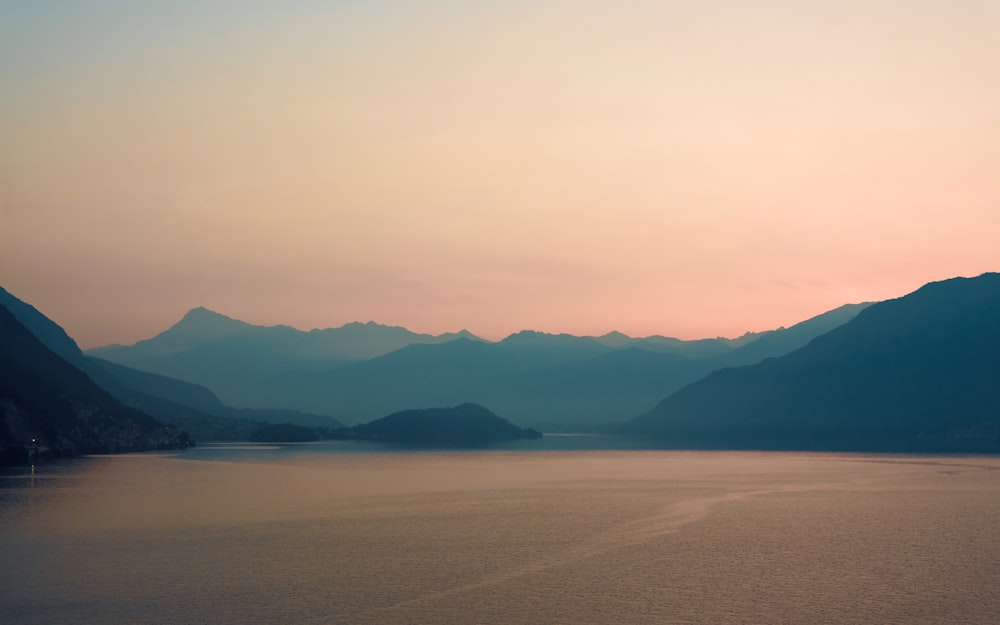 a body of water with mountains in the background