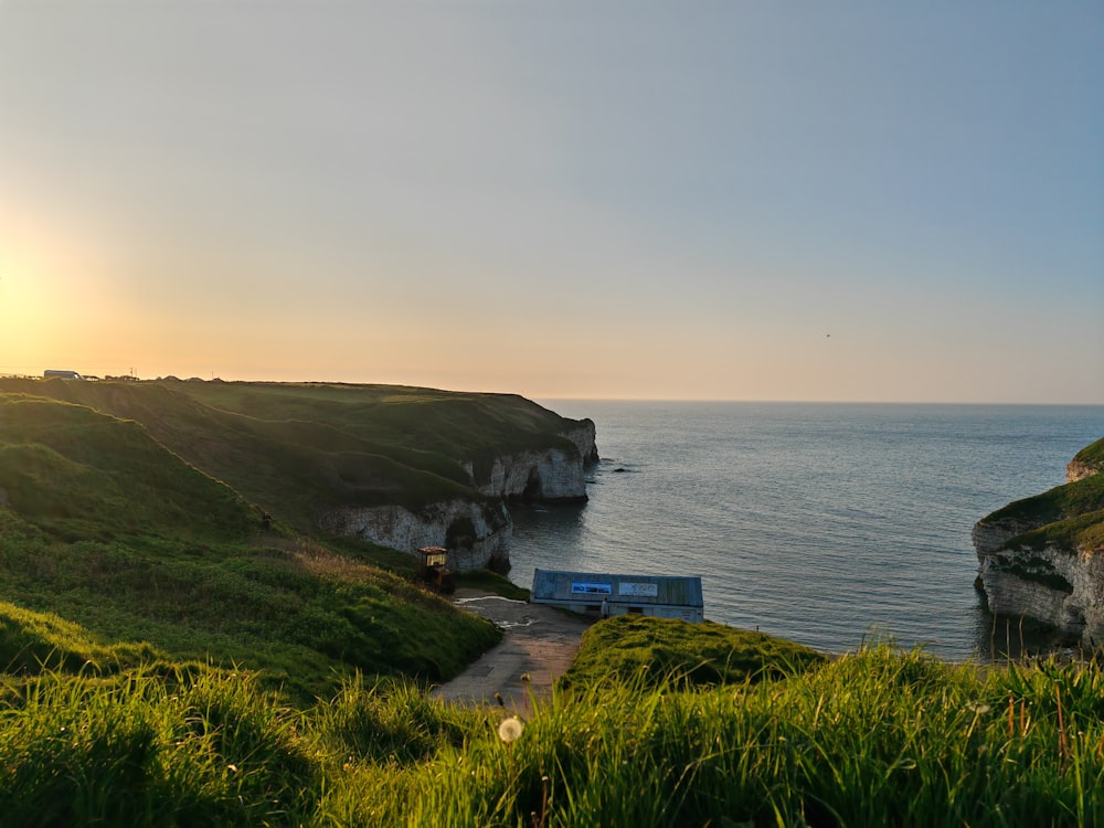 a bus is parked on the side of a cliff overlooking the ocean