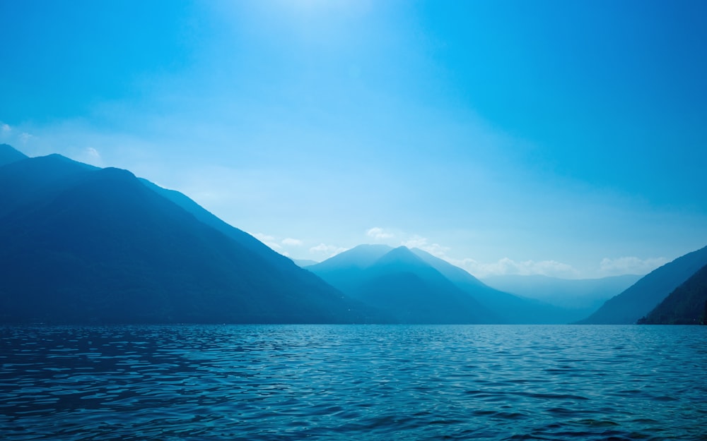 a body of water with mountains in the background