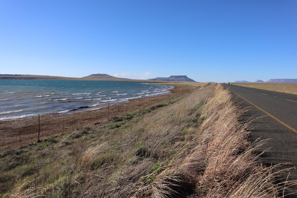 a long stretch of road next to a body of water