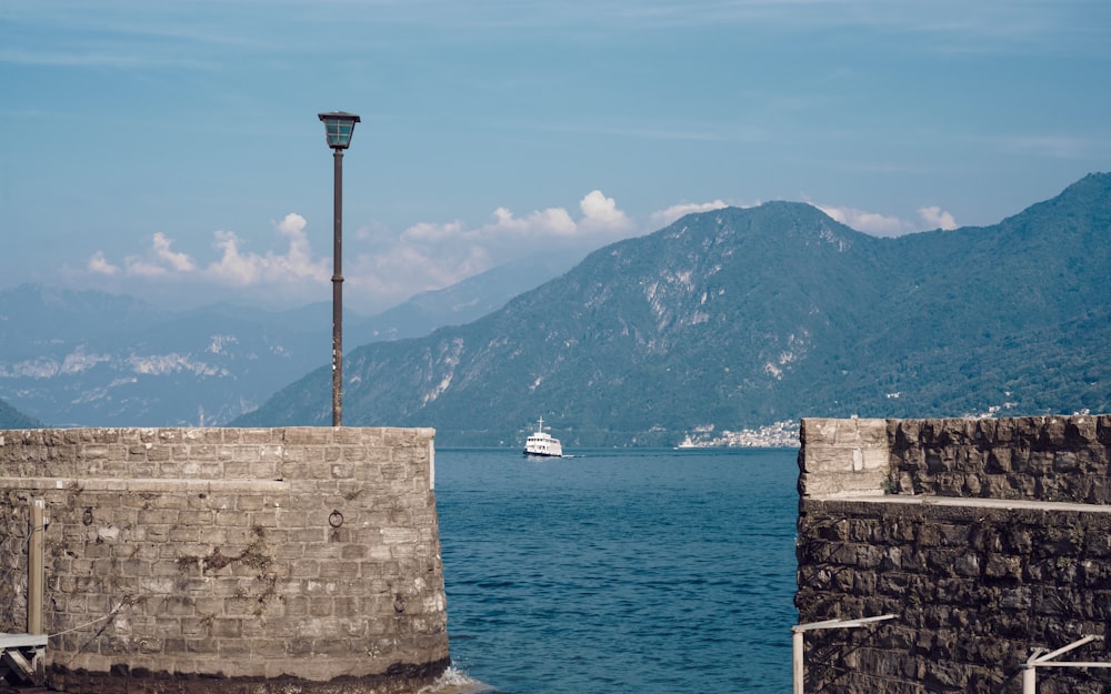 a boat is in the water near a stone wall