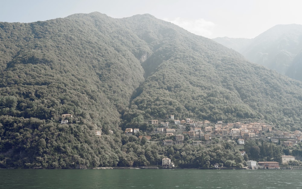 a village on the side of a mountain next to a body of water