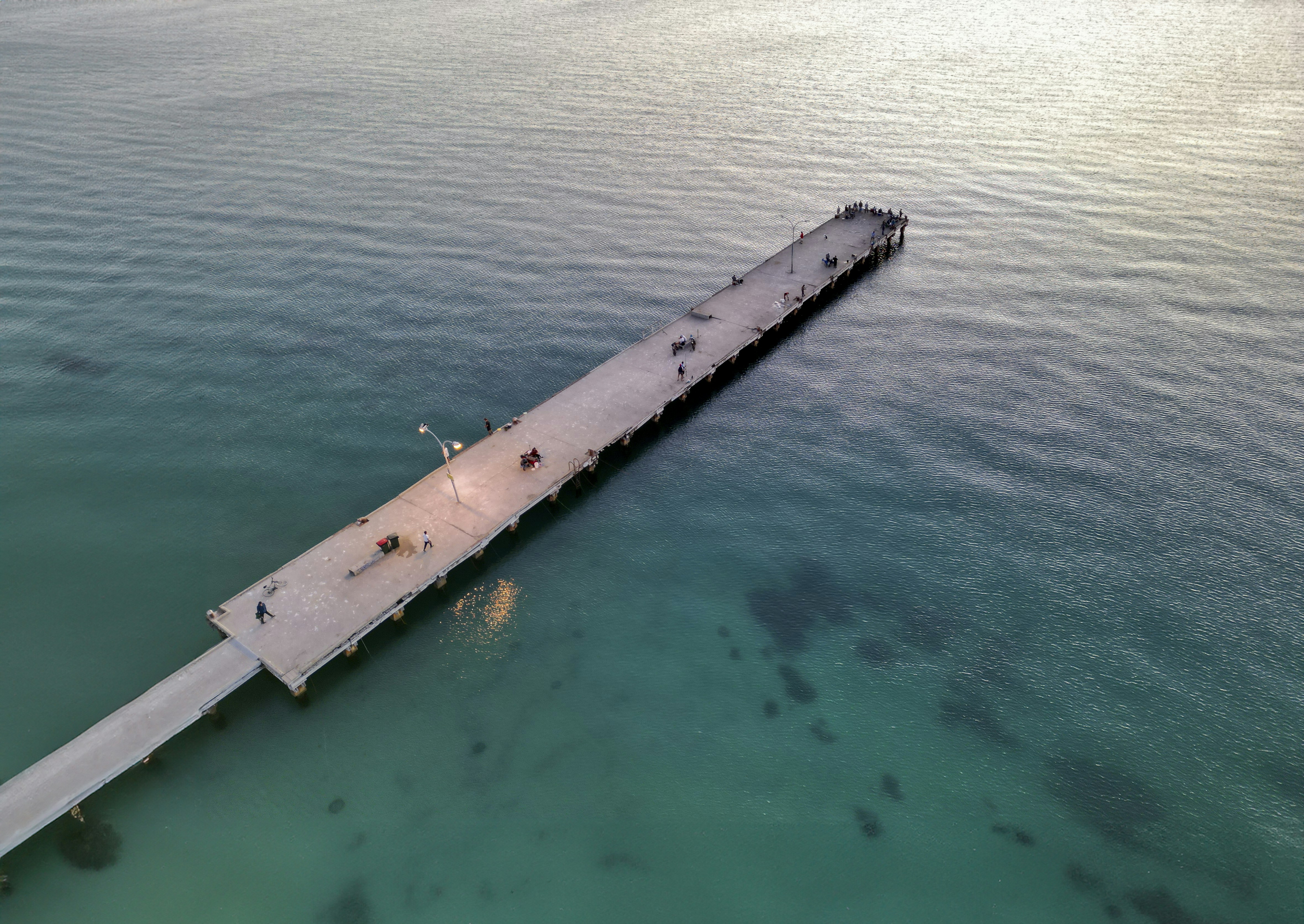 an aerial view of a pier in the ocean