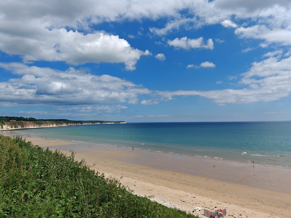 a view of a beach with a few people in the water