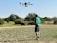 A farmer using a drone in a field for crop monitoring.