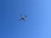 a small airplane flying through a blue sky