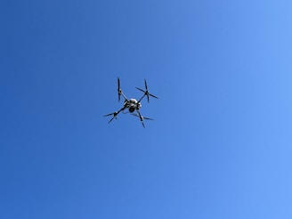 A prototype unmanned drone being tested outdoors against a clear blue sky.