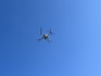 a small airplane flying through a blue sky
