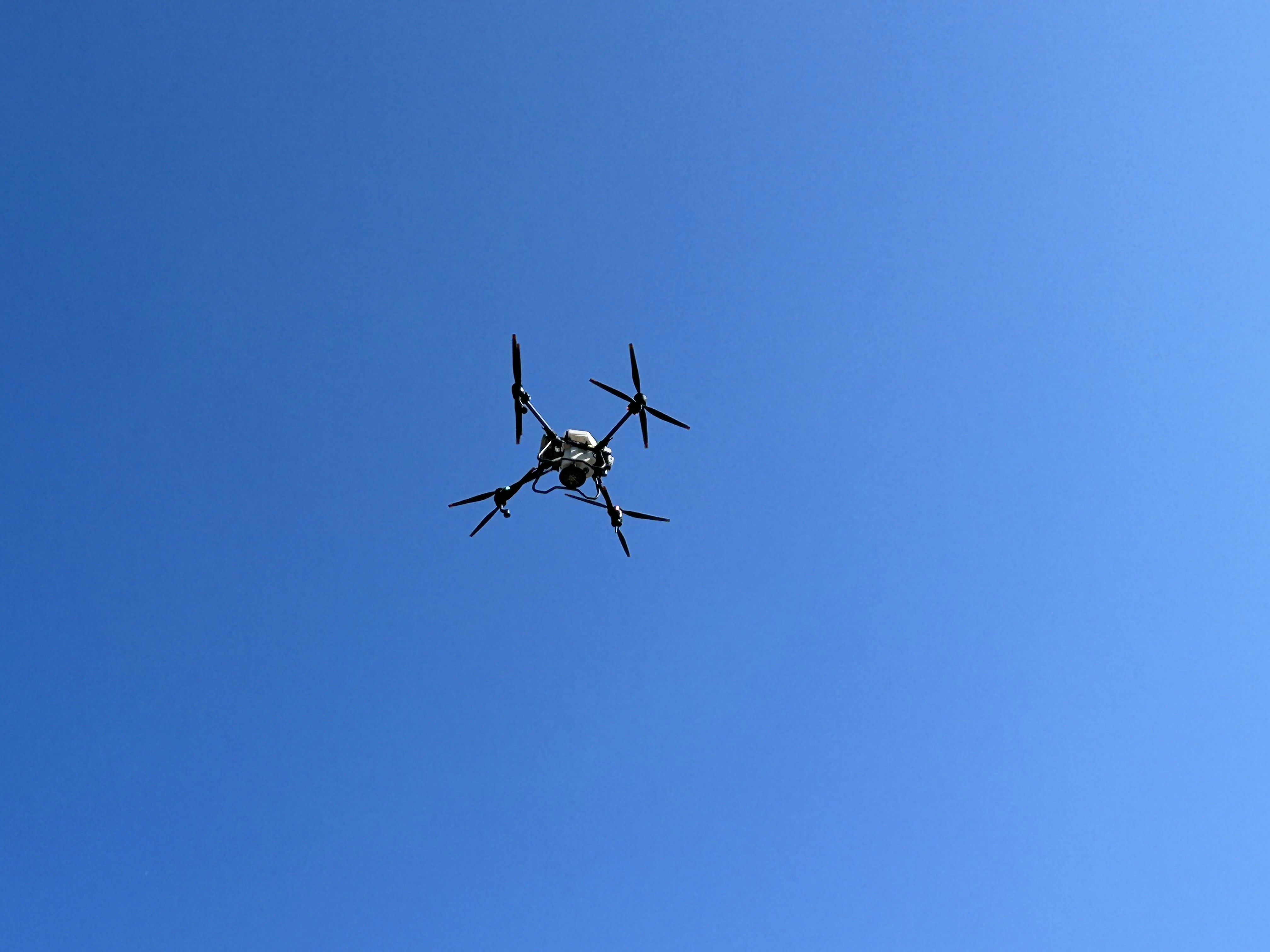 a small airplane flying through a blue sky