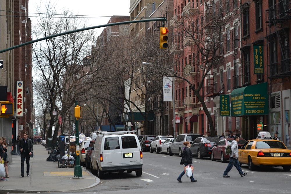 a group of people crossing a street at a traffic light