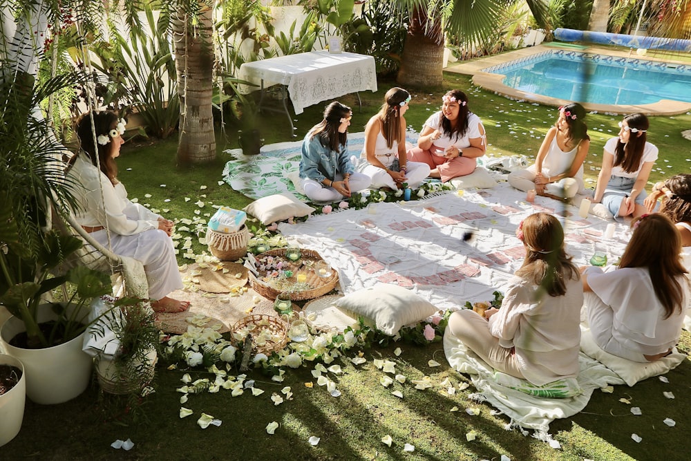Eine Gruppe von Frauen sitzt auf einer saftig grünen Wiese