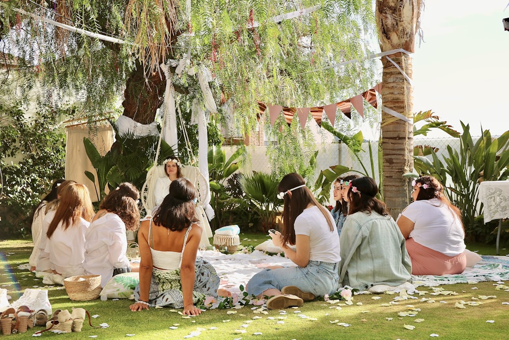 Eine Gruppe von Frauen sitzt auf einer saftig grünen Wiese
