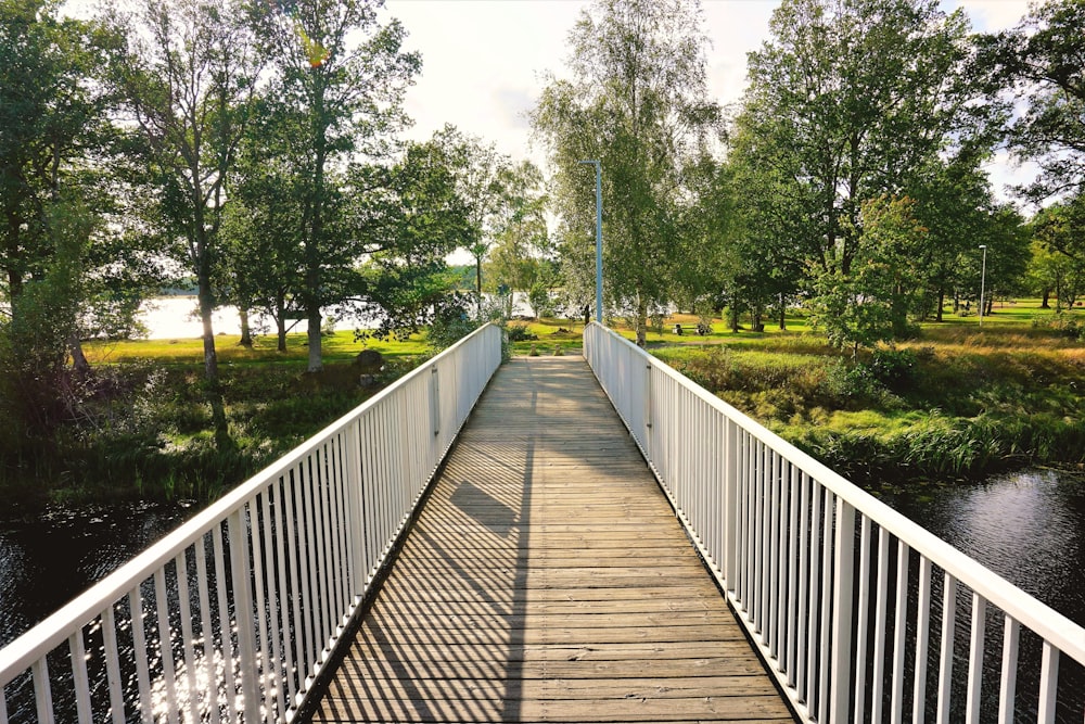 a wooden bridge over a river with trees in the background
