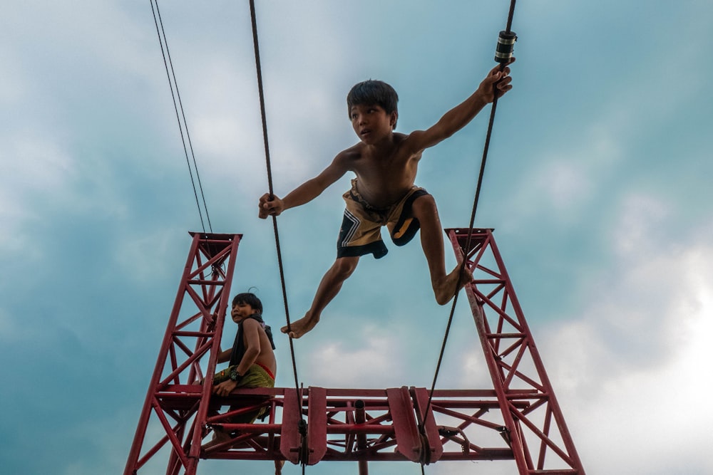 a boy on a rope course with another boy on the other side