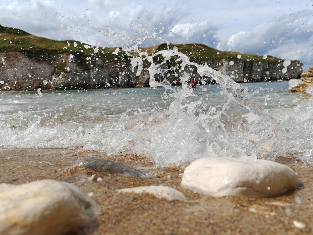 the water splashes on the beach and rocks