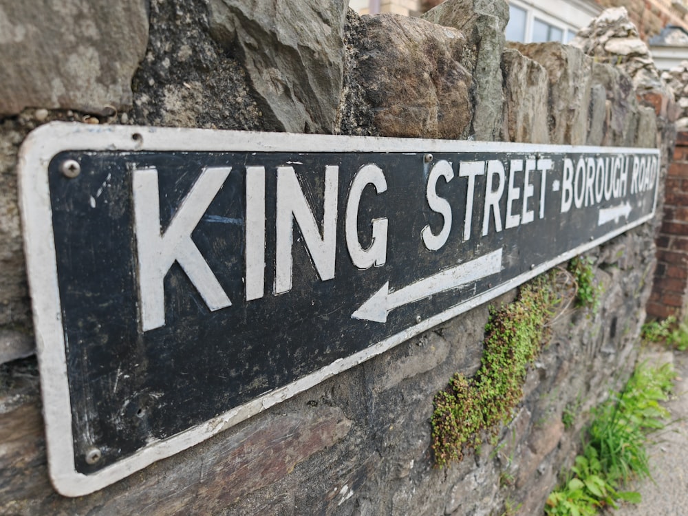 a street sign mounted to a stone wall