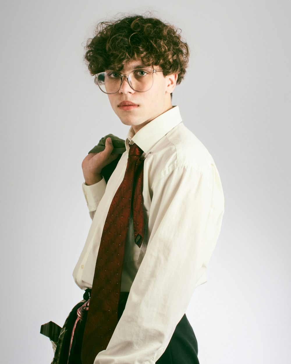 a young man wearing glasses and a tie