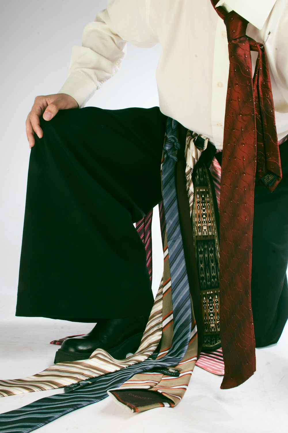 a man in a dress shirt and tie kneeling down