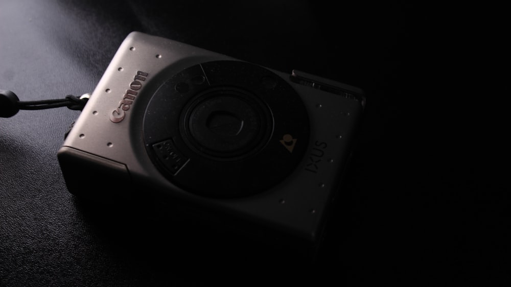 a black and silver camera sitting on top of a table