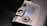 A close-up view of a section of an electronic device featuring a metallic surface with buttons and switches. A label is affixed to the surface, containing text for different greetings or messages. The layout suggests a customizable electronic message feature.