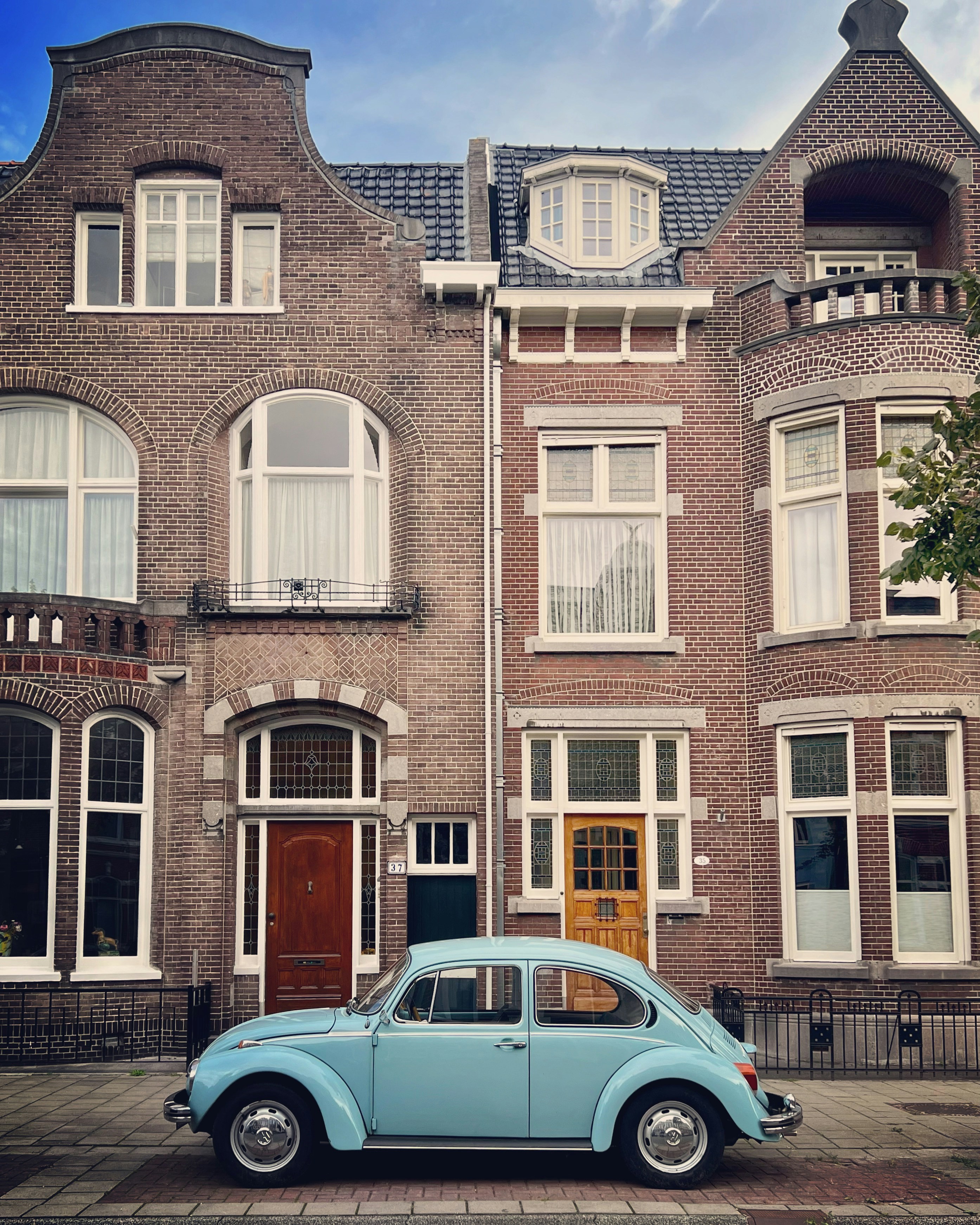 a blue car parked in front of a brick building