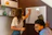 A smiling tutor explaining a concept to a student using a whiteboard in a modern classroom.