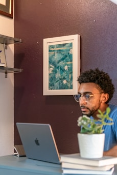 Shreya Mhaske thoughtfully working on a LinkedIn strategy at her desk, surrounded by art and advocacy books.