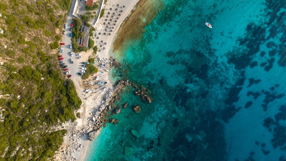 a bird's eye view of a sandy beach and clear blue water
