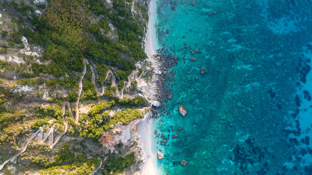 an aerial view of a sandy beach and blue water