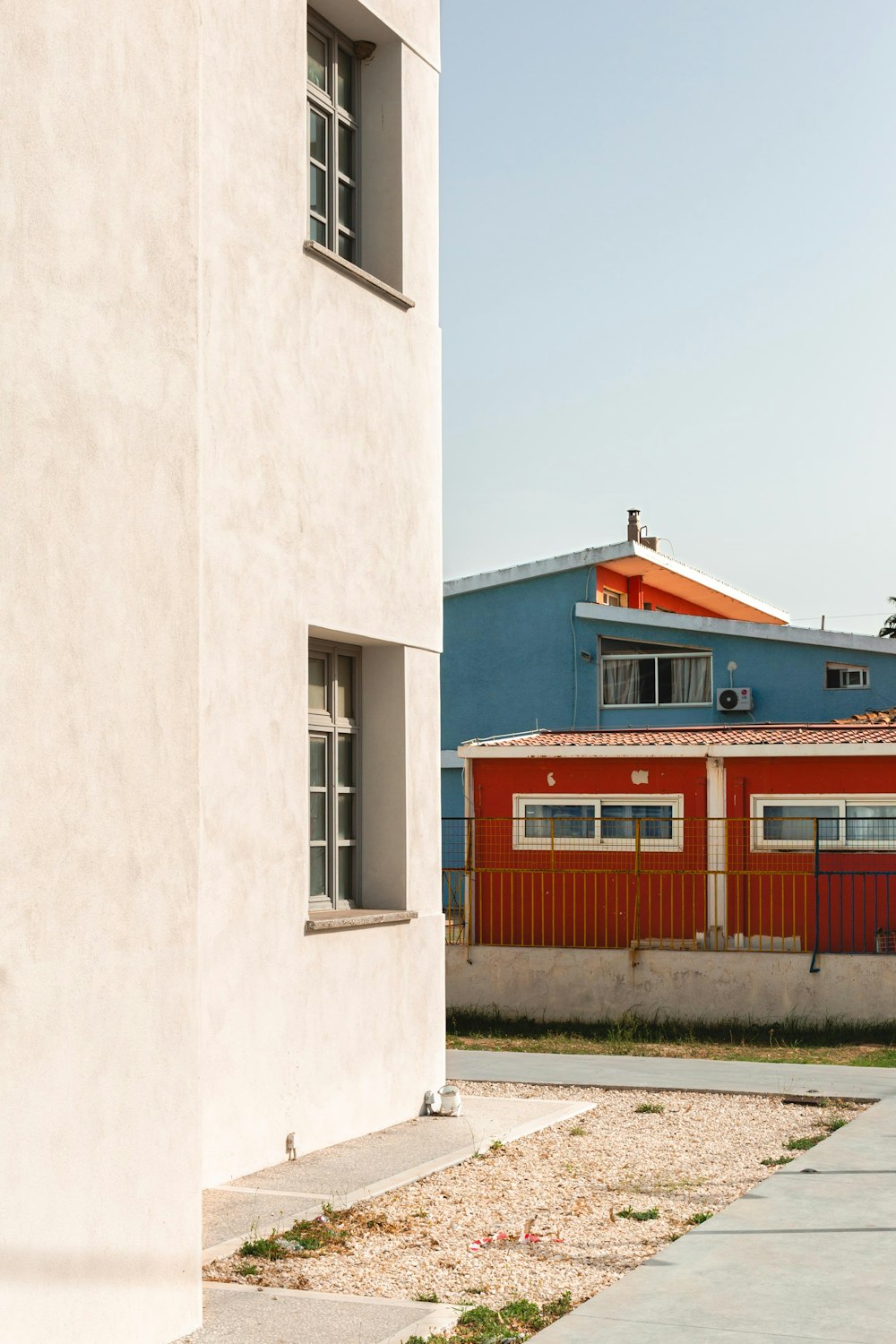 a red and white building next to a blue building