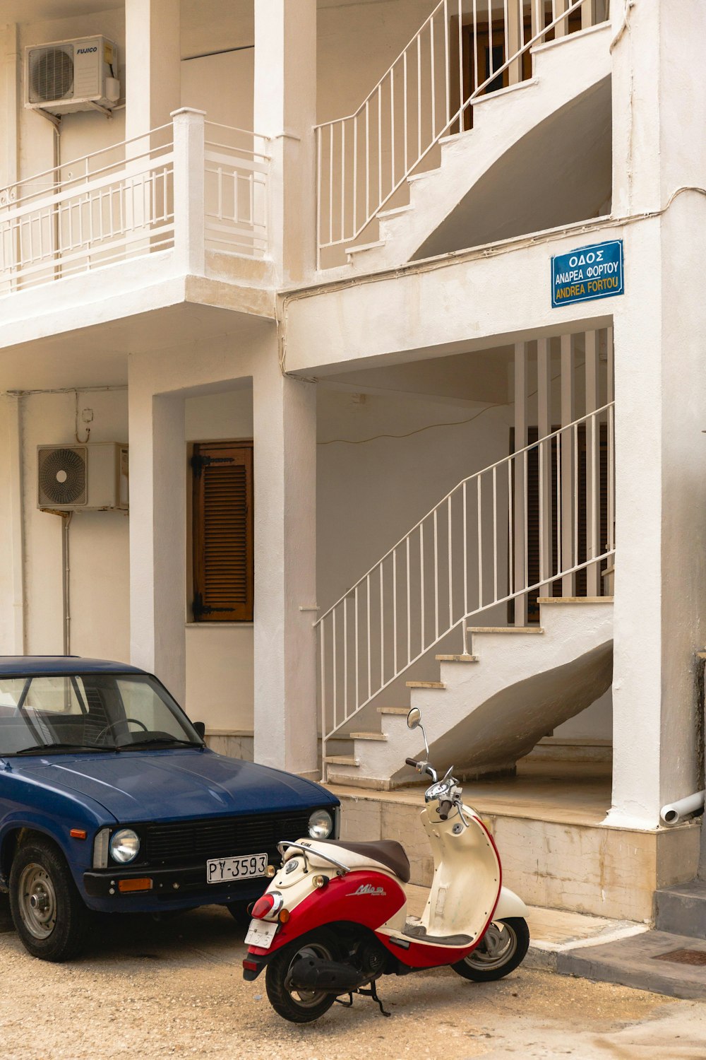 a scooter and a car parked in front of a building