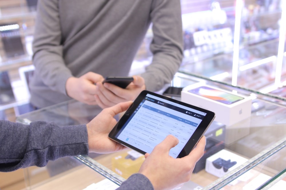 two people are looking at a tablet in a store