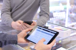 A wireless retail professional assisting a customer with device options at the sales counter.