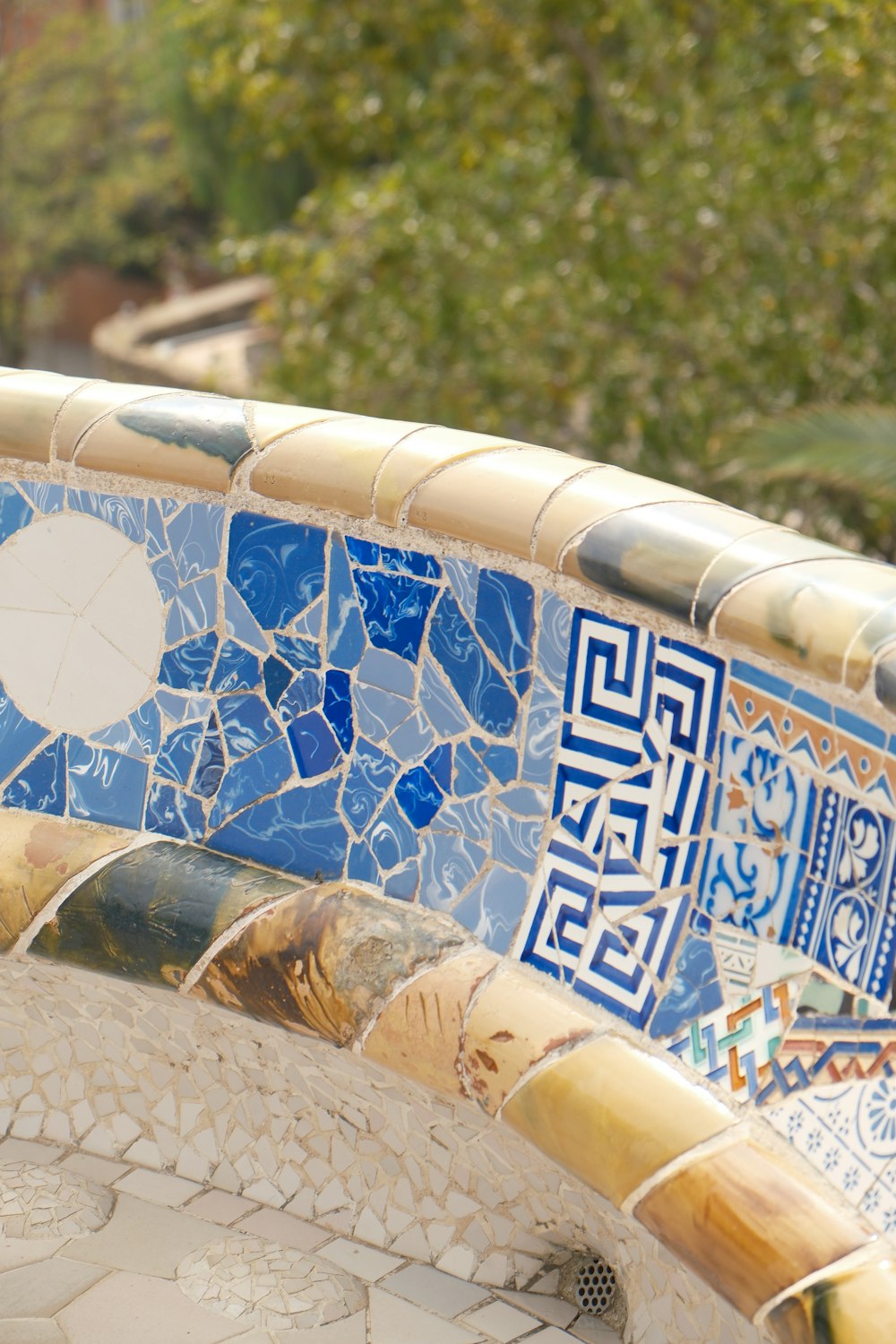 a bird is perched on a mosaic wall