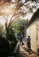 A friendly caregiver assisting a senior with a walker in a sunny garden.