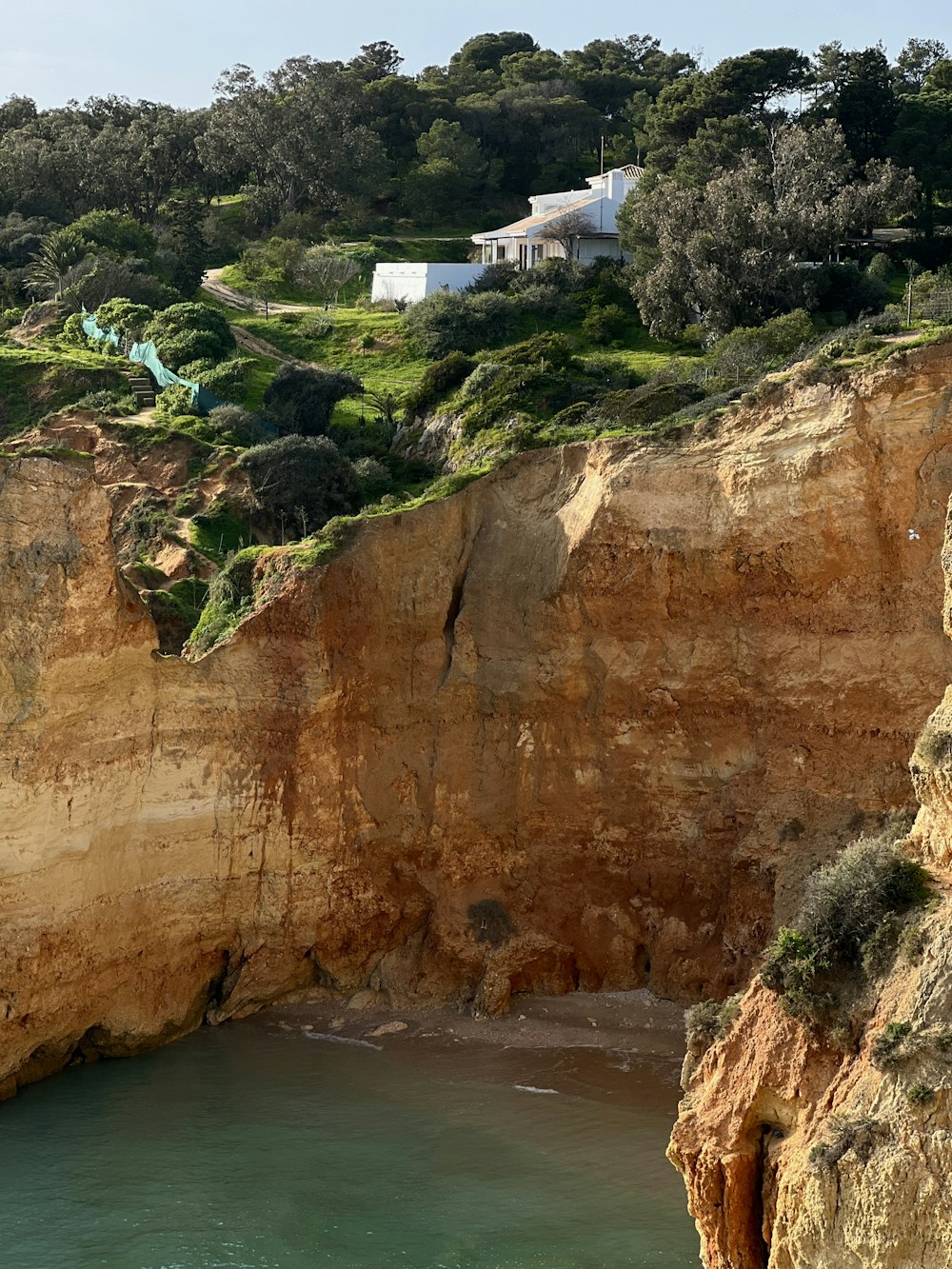 Una casa en un acantilado con vistas a un cuerpo de agua