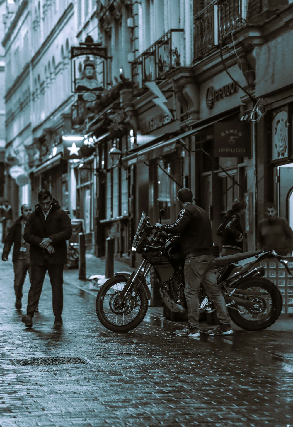 a man walking down a street next to a motorcycle