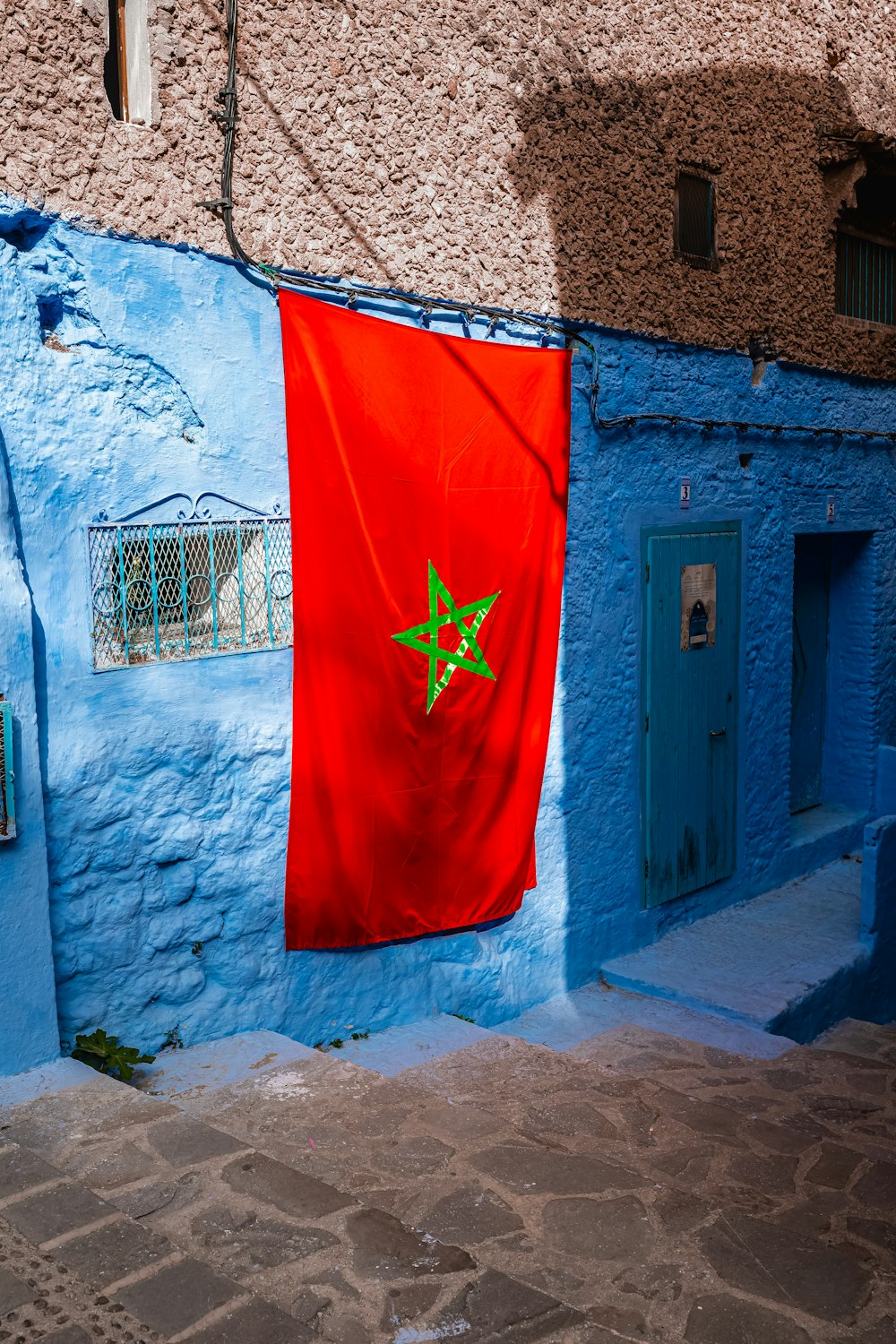 a blue building with a red flag hanging from it's side