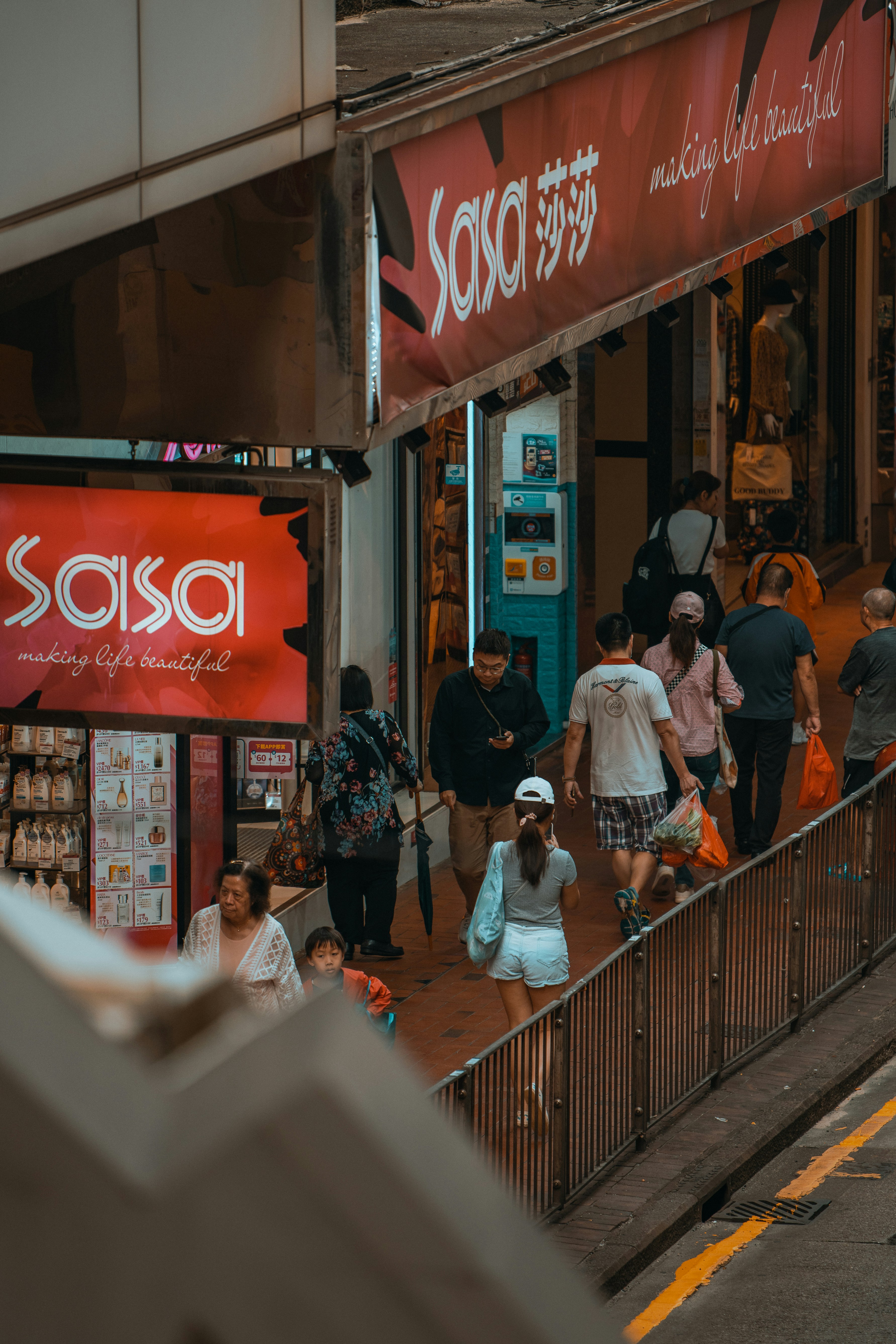 a group of people walking down a street next to a store