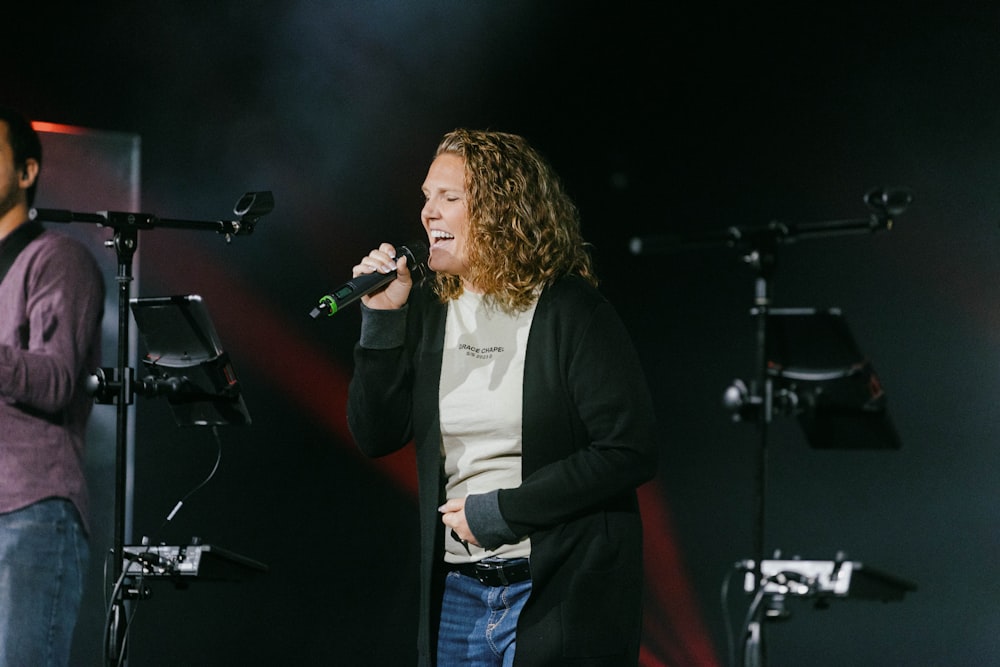 a man standing next to a microphone on top of a stage