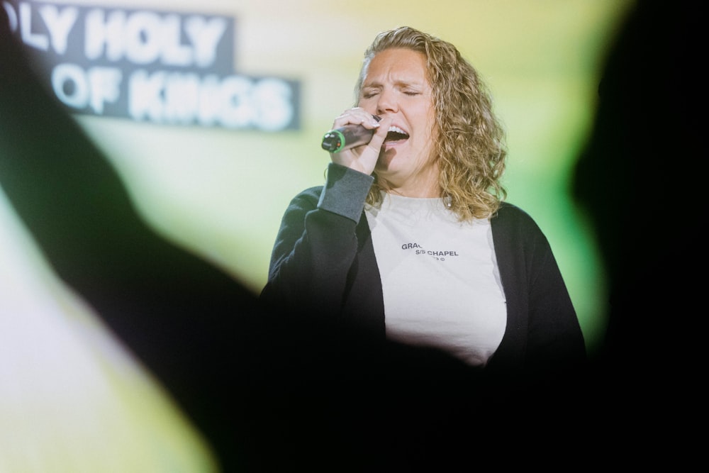 a woman singing into a microphone on stage