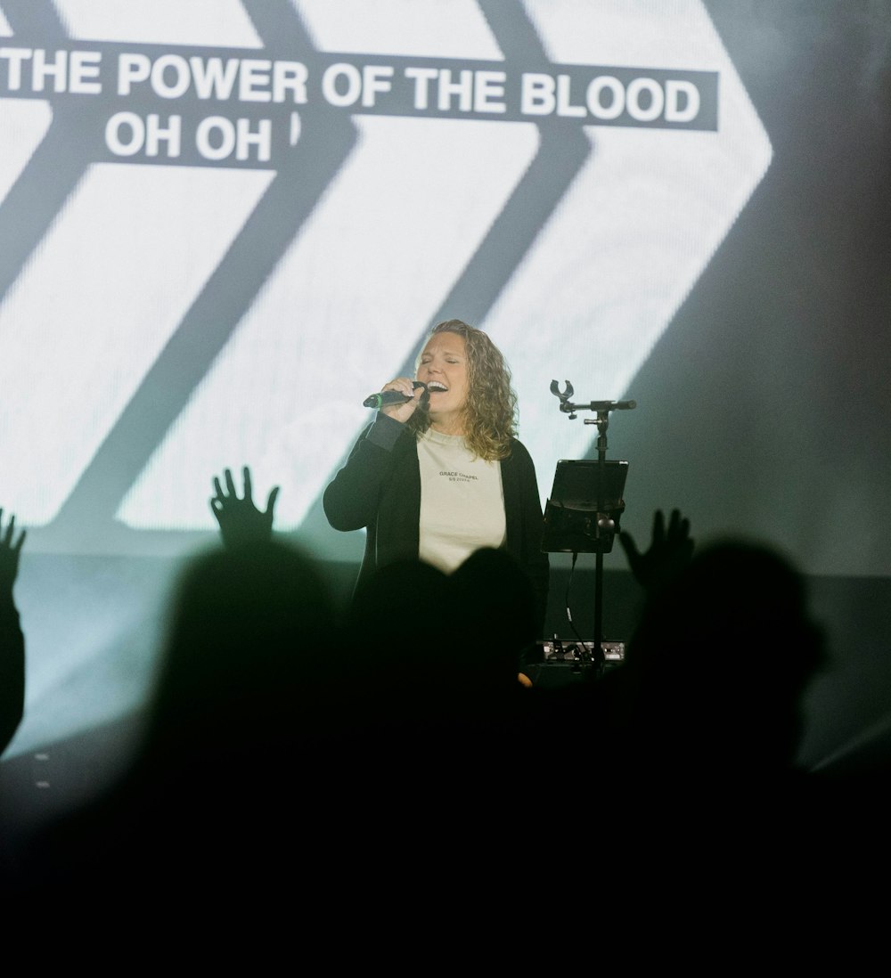 a woman standing on top of a stage holding a microphone