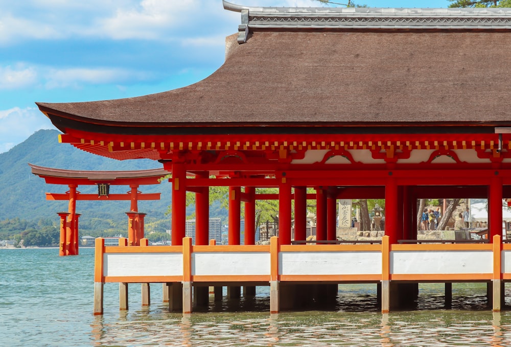 a red and white building sitting on top of a body of water