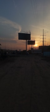 A team setting up a large outdoor advertising panel at sunset