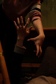 A close-up of two hands reaching out to each other in a moment of support.