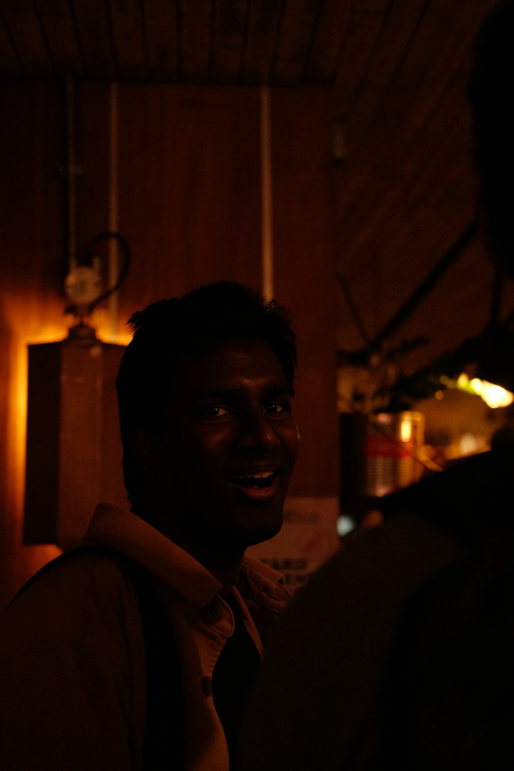 a man is smiling in a dark room