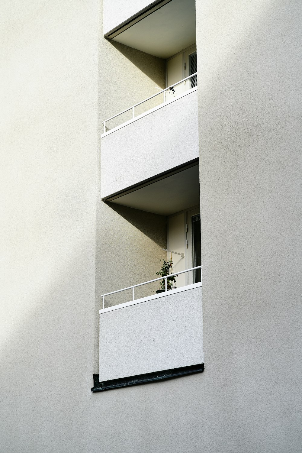 a tall white building with balconies and a balcony