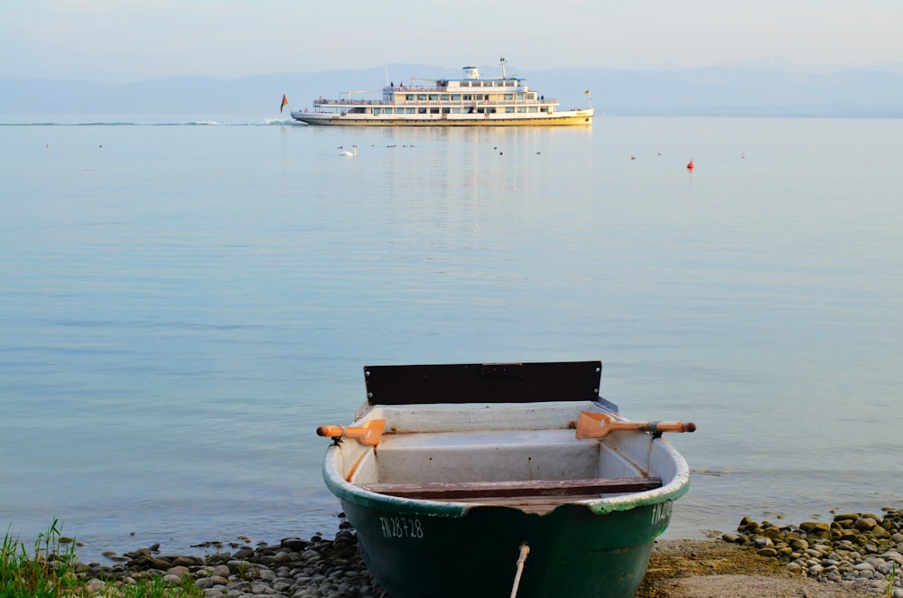 a small boat sitting on the shore of a lake