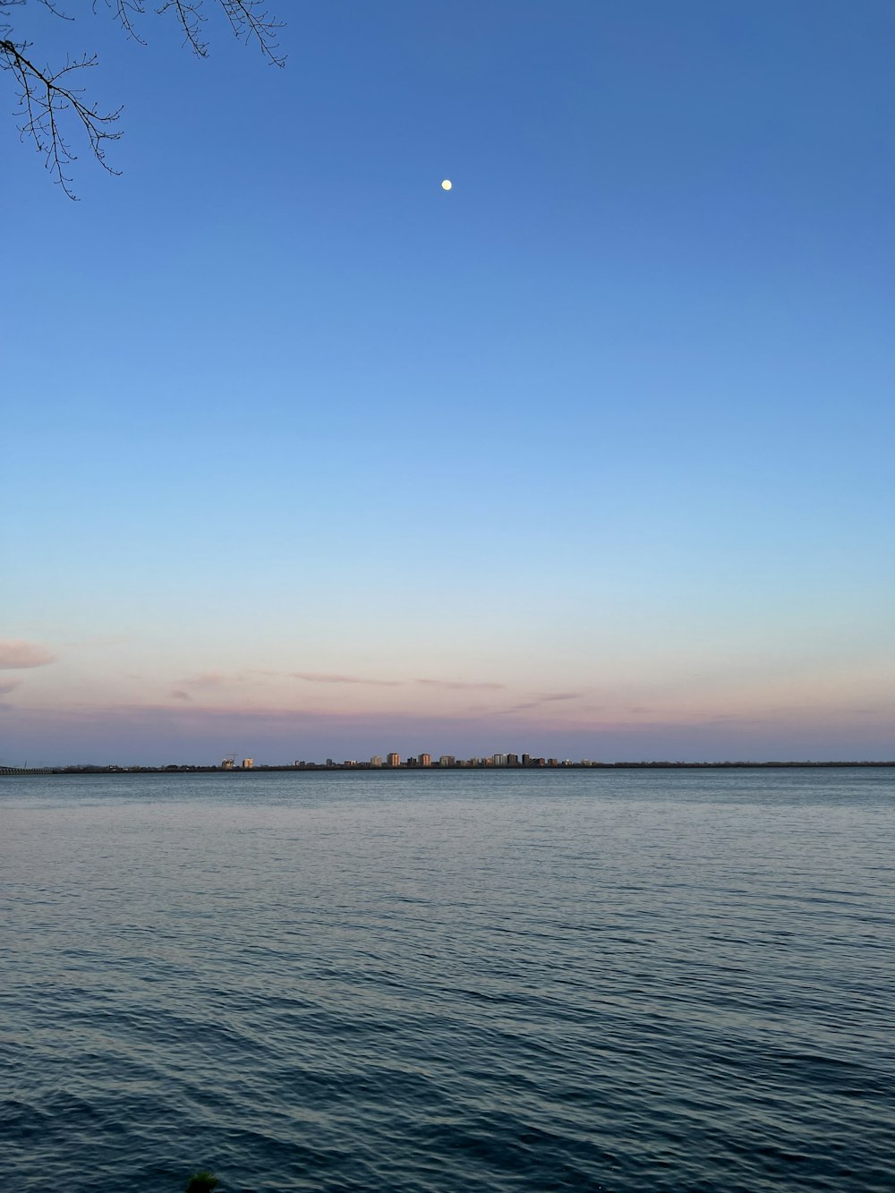 una gran masa de agua con una luna en el cielo