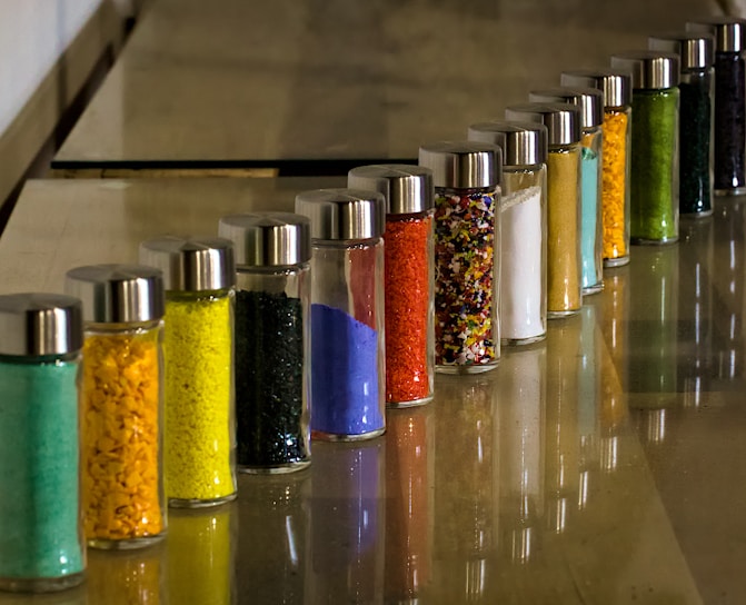 An array of colorful raw materials in small containers.